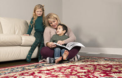 Mom and kids enjoy a book on a clean oriental area rug