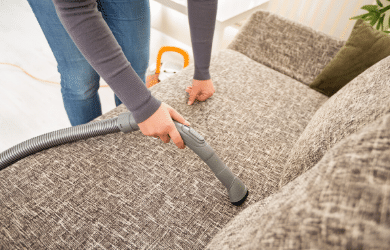 person vacuuming couch
