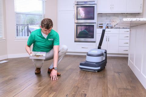 Inspecting wood floor surface during Wood Floor Cleaning service by Chem-Dry